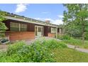 Classic single-story home featuring a brick facade, a covered porch, and mature landscaping at 7350 Field St, Arvada, CO 80005
