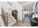 Inviting entryway featuring hardwood floors, stairs, and an open view to the living area at 26361 E 5Th Pl, Aurora, CO 80018