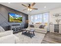 Bright living room featuring a decorative wall, plush seating, and large windows at 26361 E 5Th Pl, Aurora, CO 80018