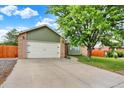 Attractive home featuring an attached two-car garage, brick accents, and a well-maintained front lawn at 915 S Mckinley Ave, Fort Lupton, CO 80621