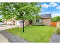 Inviting front yard with lush green lawn, complemented by mature trees, and attractive landscaping at 915 S Mckinley Ave, Fort Lupton, CO 80621