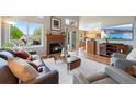 Cozy living room featuring a fireplace, wood floors, a sliding glass door, and an open view of the kitchen at 42 Blue Sage, Littleton, CO 80127