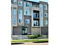 Modern condo building with brick and siding, featuring balconies and well-maintained landscaping at 420 E Fremont Pl # 203, Centennial, CO 80122