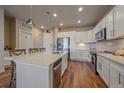 Modern kitchen features white cabinets, stainless steel appliances, and a quartz countertop island at 420 E Fremont Pl # 203, Centennial, CO 80122