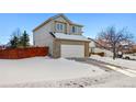 Two-story house with a white garage door and snow-covered driveway at 600 Balsa Dr, Castle Rock, CO 80104