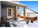 Covered porch with a wooden swing and brick columns at 600 Balsa Dr, Castle Rock, CO 80104