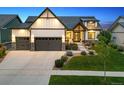 Beautiful home with a well-manicured lawn, stone accents, and a three-car garage at 2932 Heron Lakes Pkwy, Berthoud, CO 80513
