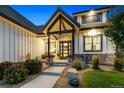 Inviting front porch with stone accents, a well-maintained lawn, and decorative planters at 2932 Heron Lakes Pkwy, Berthoud, CO 80513