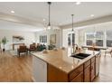 Open kitchen with a large island and an open floor plan to the dining and living rooms at 7812 Blue Water Ln, Castle Rock, CO 80108