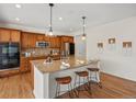 This kitchen boasts warm wood cabinets, granite counters, and a large island with seating and modern pendant lights at 7812 Blue Water Ln, Castle Rock, CO 80108