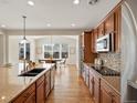 A modern kitchen with wood floors features granite countertops, wood cabinets, and stainless steel appliances at 7812 Blue Water Ln, Castle Rock, CO 80108