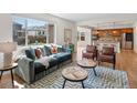 Comfortable living room with a large window, plush sofa, and stylish decor open to kitchen at 7812 Blue Water Ln, Castle Rock, CO 80108