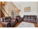 Spacious living room featuring hardwood floors, comfortable seating, and a staircase at 25850 E 3Rd Ave, Aurora, CO 80018