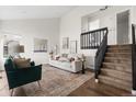 Bright living room with tall ceilings, hardwood floors, neutral tones, and modern staircase at 5991 W 68Th Ave, Arvada, CO 80003
