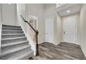 Inviting entryway featuring carpeted stairs, wood-look floors, and neutral color palette at 4733 S Wenatchee Cir, Aurora, CO 80015