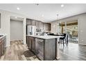 Kitchen features stainless steel appliances, wood flooring, and a central island with white countertop and seating at 4733 S Wenatchee Cir, Aurora, CO 80015