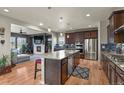 Spacious kitchen features granite counters, stainless appliances, and open access to the living room and fireplace at 1794 Wright Dr, Erie, CO 80516