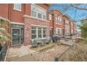 Charming red brick townhome with a cozy outdoor patio and seating area at 8977 E Otero Pl, Centennial, CO 80112