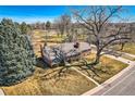 An aerial view of a well-maintained home with a large tree, a paved driveway, and a landscaped yard at 13 Wedge Way, Littleton, CO 80123