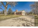 A wide shot of a single Gathering home with an attached garage and mature landscaping on a sunny day at 13 Wedge Way, Littleton, CO 80123