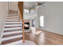 Bright living room with vaulted ceiling, fireplace, hardwood floors, and staircase at 20764 E 47Th Ave, Denver, CO 80249