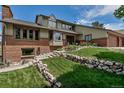 Charming home with a well-manicured lawn, stone retaining wall, and inviting entrance at 3254 Red Tree Pl, Castle Rock, CO 80104