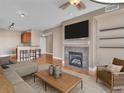 Spacious living room featuring a fireplace, TV, hardwood floors, and bar stool seating to the kitchen at 9019 E Panorama Cir # D217, Englewood, CO 80112