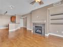 Open-concept living space with fireplace, hardwood floors, and bar stool seating to the kitchen at 9019 E Panorama Cir # D217, Englewood, CO 80112