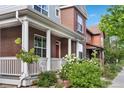 Beautiful home with a classic front porch, brick accents, and blossoming shrubs, perfect for outdoor enjoyment at 8029 E 23Rd Ave, Denver, CO 80238