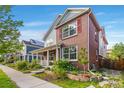 Attractive two-story home featuring a brick facade, covered porch, and well-maintained landscaping at 8029 E 23Rd Ave, Denver, CO 80238