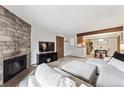 Comfortable living room features a stone fireplace and seamless flow to dining area at 203 Wright St # 102, Lakewood, CO 80228
