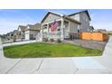 A home featuring a quaint front porch, well-manicured lawn, and an attached two-car garage at 17765 Faraday St, Broomfield, CO 80023