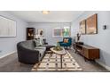 Cozy living room with a gray sectional, vibrant teal chair, modern rug, and natural light from the window at 1260 York St # 204, Denver, CO 80206