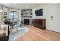 Cozy living room featuring a stone fireplace, sleek furnishings, and hardwood flooring at 8335 Fairmount Dr # 11-203, Denver, CO 80247
