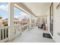 Inviting covered front porch with white columns, railing, and an outdoor welcome mat at 8977 Crossington Way, Lone Tree, CO 80124