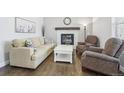 Cozy living room showcasing a fireplace, hardwood floors, and neutral-toned furniture at 8977 Crossington Way, Lone Tree, CO 80124