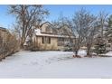 Inviting two-story home with snow-covered yard and mature trees at 1390 W Gill Pl, Denver, CO 80223