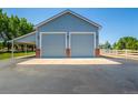 Detached two-car garage with additional covered parking and brick accents at 6460 E 165Th Ct, Brighton, CO 80602