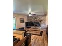 Inviting living room features a brick fireplace, hardwood floors and a ceiling fan at 4827 S Lewis Ct, Littleton, CO 80127