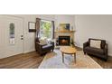 Cozy living room with a fireplace, two chairs, a table, and plenty of natural light at 4860 S Salida Ct, Aurora, CO 80015