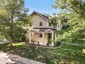 Inviting two-story home with a charming front porch and lush landscaping at 751 Poplar St, Denver, CO 80220