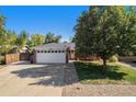 Brick ranch home with attached garage and mature tree at 6062 Garrison St, Arvada, CO 80004