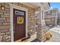 Inviting front entrance with a wreath and stonework at 9760 Mayfair St # A, Englewood, CO 80112