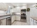 Bright kitchen with white cabinets, stainless steel appliances, and gray countertops at 6410 Independence Way, Arvada, CO 80004