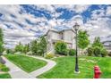 Beautiful townhomes featuring a well-manicured lawn, a walking path, and lush landscaping at 7277 W Adriatic Cir, Lakewood, CO 80227