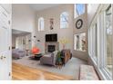 Bright living room with hardwood floors, fireplace, large windows, and modern furnishings at 7712 S Monaco E Cir, Centennial, CO 80112