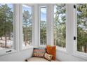 A cozy reading nook is framed by scenic views of snow-covered trees outside at 160 Bristlecone Way, Boulder, CO 80304