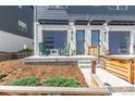 Inviting townhouse front porch with blue garage doors, green rocking chairs, and landscaped walkway at 2080 Alcott Way, Broomfield, CO 80023