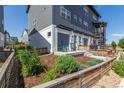 Modern townhouse with a fenced front yard and garden featuring green rocking chairs and a patio at 2080 Alcott Way, Broomfield, CO 80023