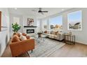Cozy living room featuring a tiled fireplace, modern furniture, and a large window with neighborhood views at 1136 Hillside Ln, Louisville, CO 80027